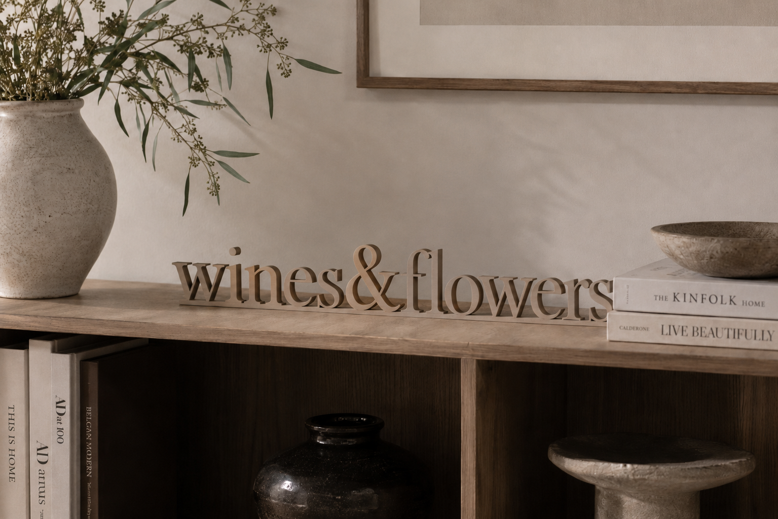 Wines & Flowers Schriftzug als 3D-Objekt auf einem Holzregal mit Vase und Büchern